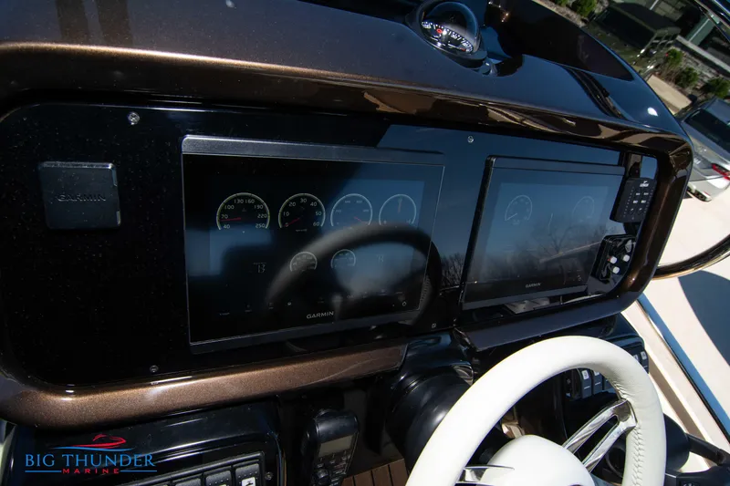 Slide: The Image of 2024 Invictus GT320 boat dashboard with dual Garmin displays and white steering wheel. - 37