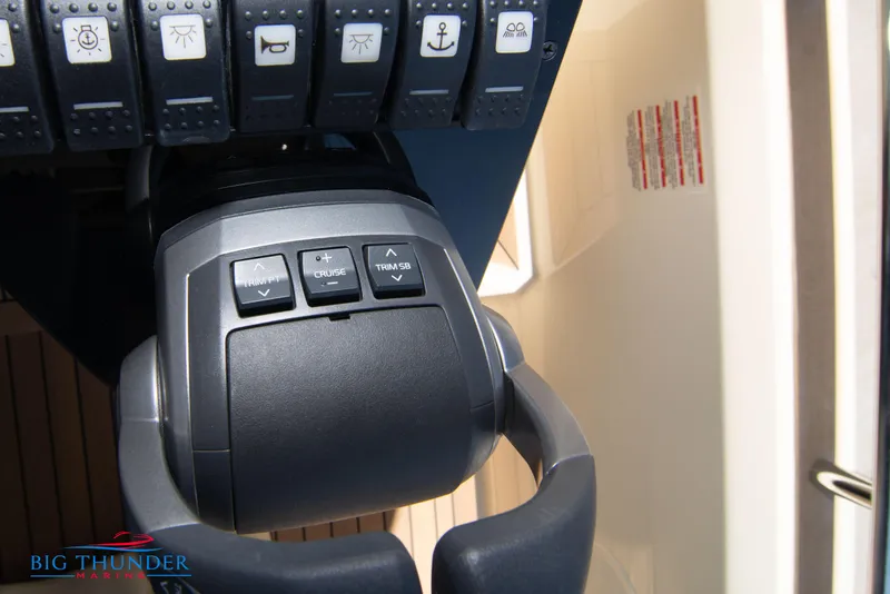 Slide: The Image of Close-up of the 2024 Invictus GT320 boat throttle control and dashboard buttons. - 49