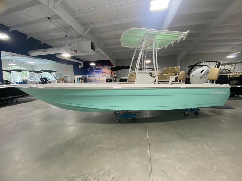 Slide: The Image of 2024 Savannah 210X boat in showroom, mint green hull, T-top canopy. - 0