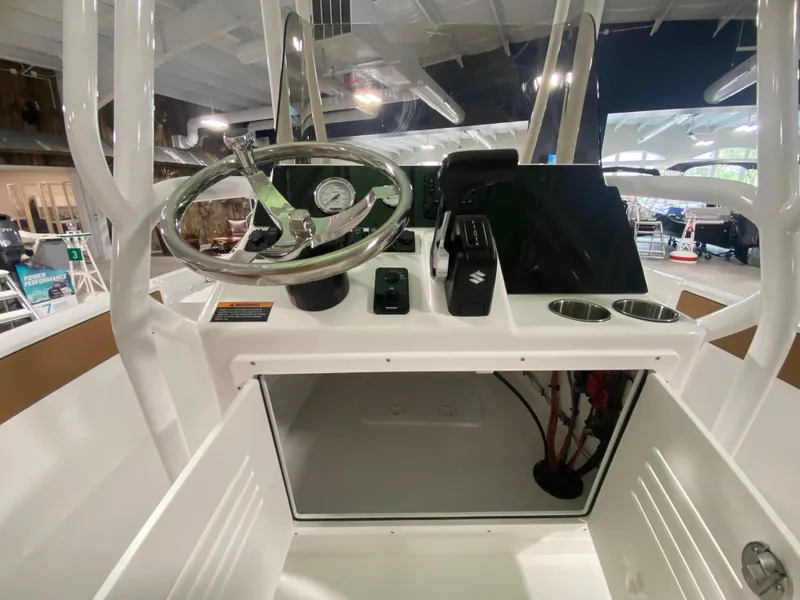 Slide: The Image of 2024 Savannah 210X boat console with steering wheel, controls, and storage compartment. - 12