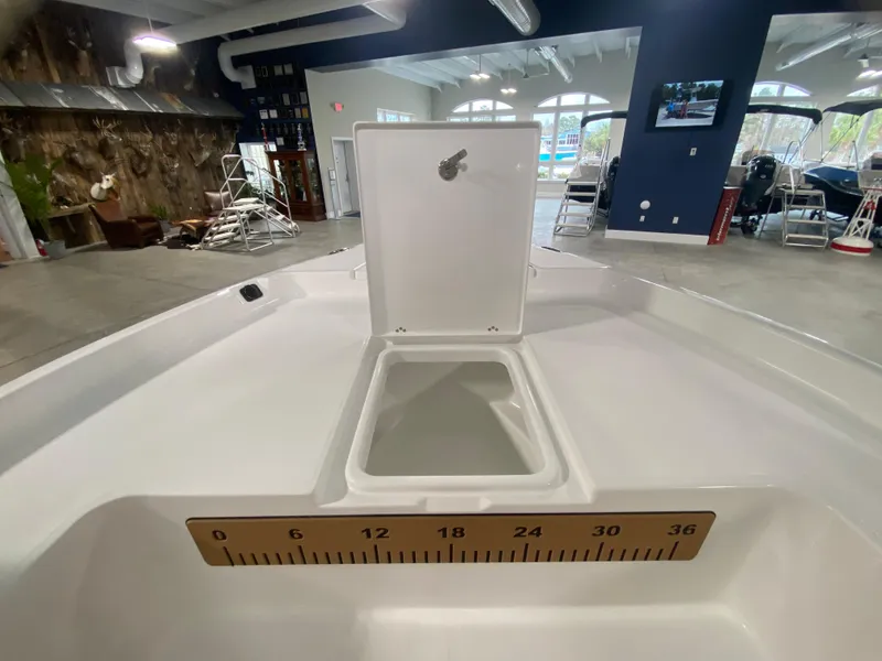 Slide: The Image of 2024 Savannah 210X boat interior with open storage compartment and measuring ruler. - 17