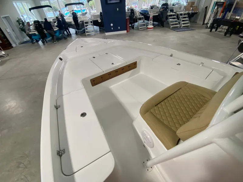 Slide: The Image of 2024 Savannah 210X boat interior at showroom, featuring tan seating and spacious deck. - 13