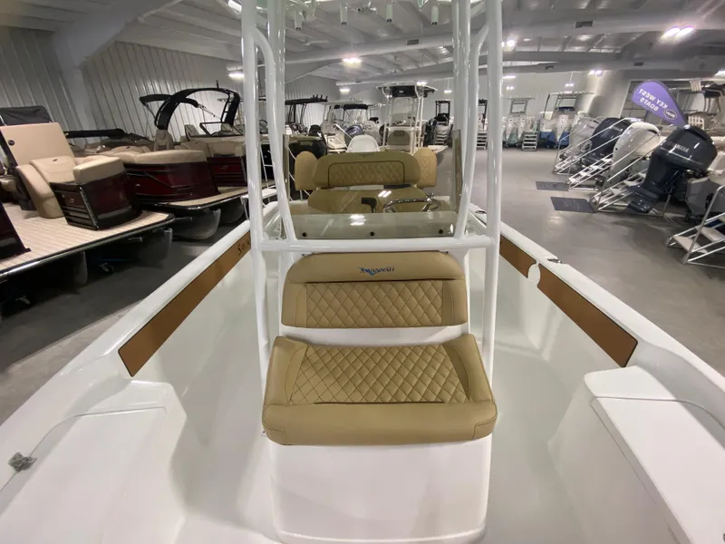 Slide: The Image of 2024 Savannah 210X boat interior with tan diamond-stitched seats in a showroom. - 14