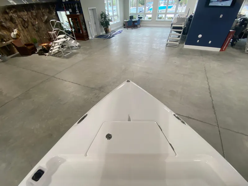 Slide: The Image of Savannah 210X 2024 boat interior in showroom with modern decor and large windows. - 19