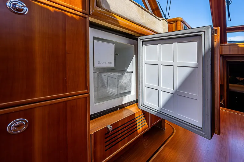Slide: The Image of Open refrigerator on 2011 Hunt Yachts 52, showcasing wooden cabinetry and interior. - 28
