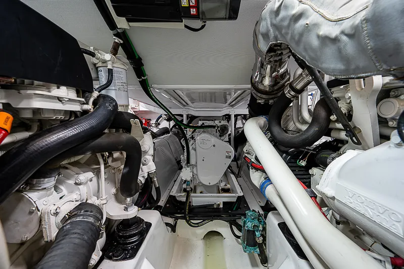 Slide: The Image of Engine room of a 2011 Hunt Yachts 52, showcasing mechanical components and piping. - 48