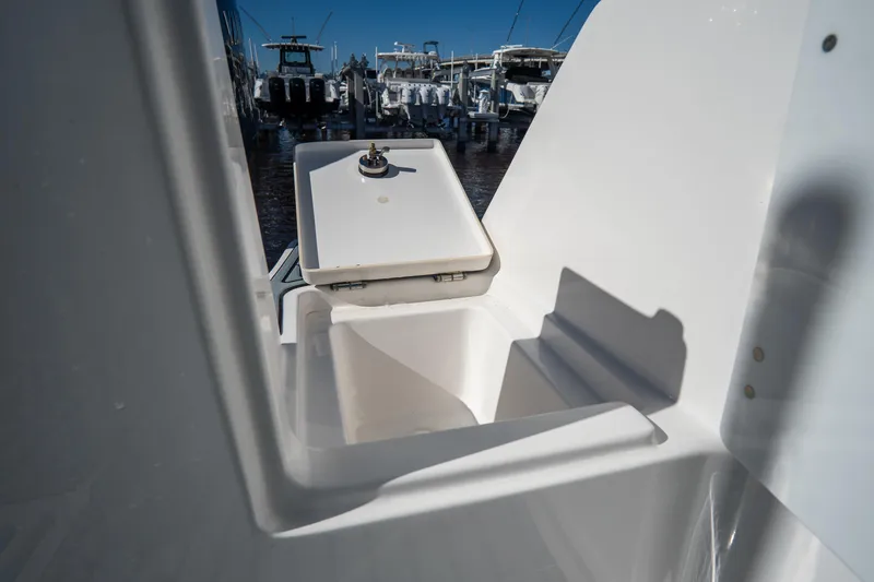 Slide: The Image of 2022 Tidewater 292CC Adventure boat storage compartment with open lid. - 11