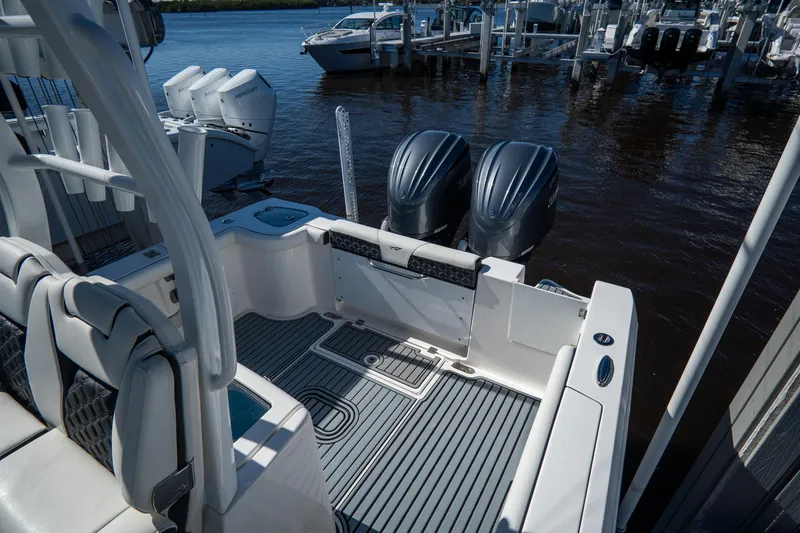 Slide: The Image of 2022 Tidewater 292CC Adventure boat with twin engines docked at a marina. - 15