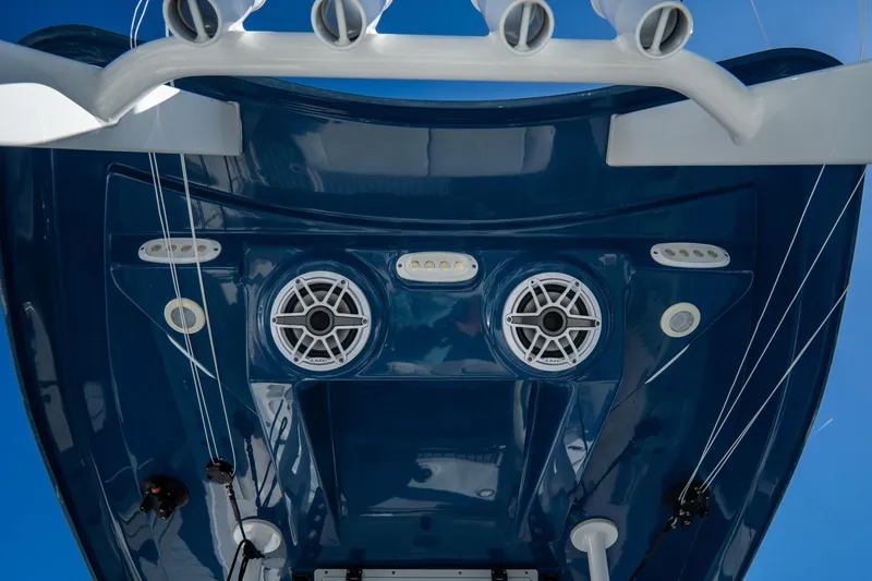 Slide: The Image of 2022 Tidewater 292CC Adventure boat, blue hull, featuring speakers and fishing rod holders. - 26