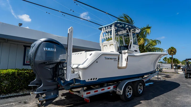 Slide: The Image of 2022 Tidewater 292CC Adventure boat on trailer, featuring Yamaha engine, parked outdoors. - 3