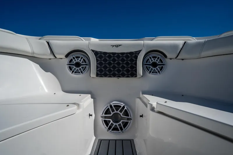 Slide: The Image of 2022 Tidewater 292CC Adventure boat interior with speakers and seating, under clear blue sky. - 43
