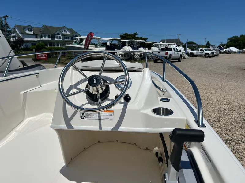 Slide: The Image of 2024 Boston Whaler 130 Super Sport boat interior with steering wheel and control panel. - 5