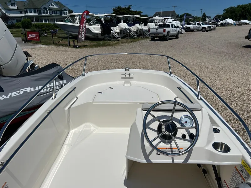Slide: The Image of 2024 Boston Whaler 130 Super Sport boat interior with steering wheel and dashboard. - 7