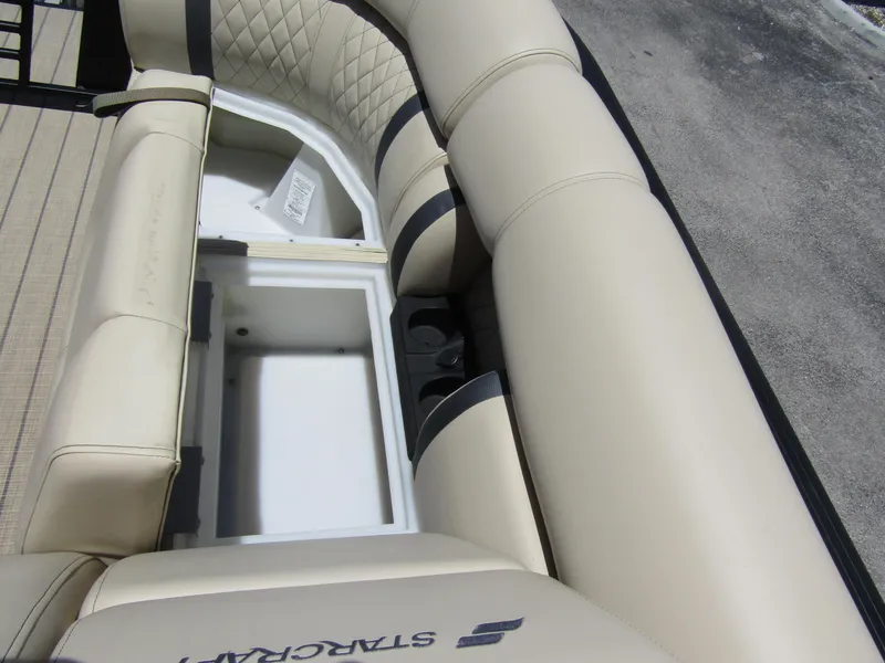 Slide: The Image of 2024 Starcraft RX 23 Q DC boat interior with beige seating and storage compartment. - 12