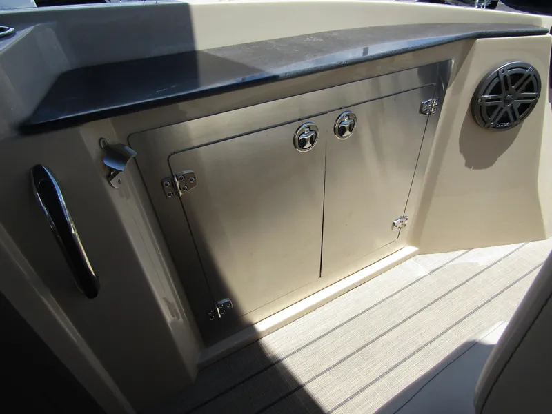 Slide: The Image of 2024 Starcraft RX 23 Q DC boat interior storage compartment with stainless steel doors. - 28