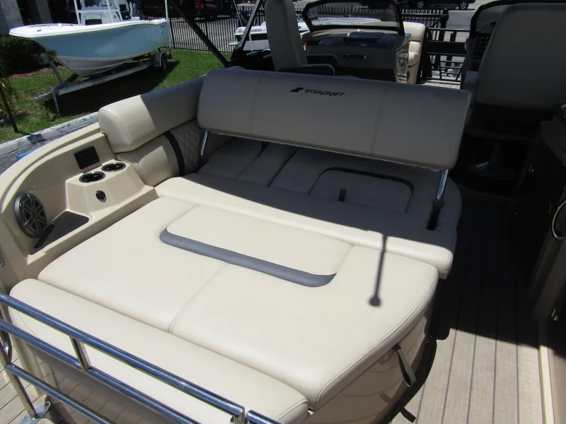 Slide: The Image of 2024 Starcraft RX 23 Q DC boat interior with beige seating and cup holders. - 31