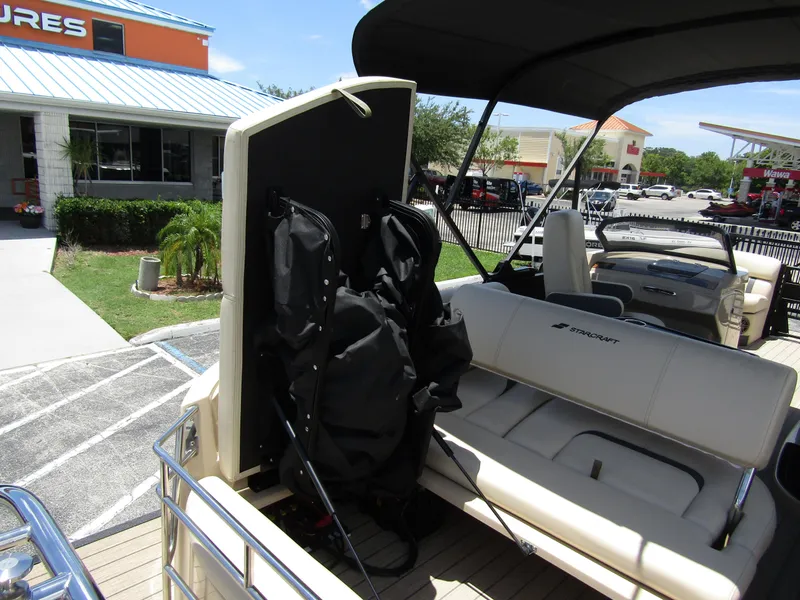 Slide: The Image of 2024 Starcraft RX 23 Q DC boat interior with seating and storage compartment. - 32