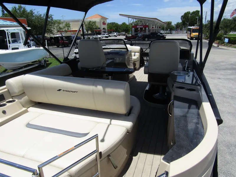 Slide: The Image of 2024 Starcraft RX 23 Q DC boat interior with beige seating and black accents. - 36
