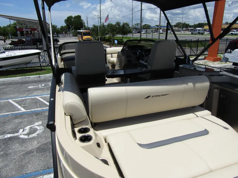 Slide: The Image of 2024 Starcraft RX 23 Q DC boat interior with beige seating and cup holders. - 37