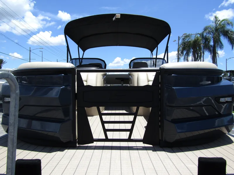 Slide: The Image of 2024 Starcraft RX 23 Q DC pontoon boat with black canopy and sleek design. - 6
