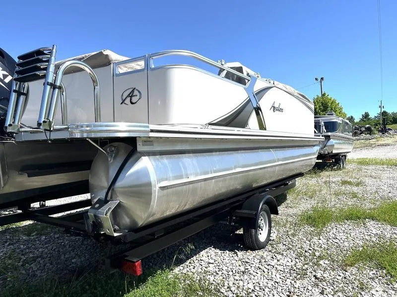 Slide: The Image of 2024 Avalon 2185 LSZ Cruise pontoon boat on a trailer in a gravel lot. - 0