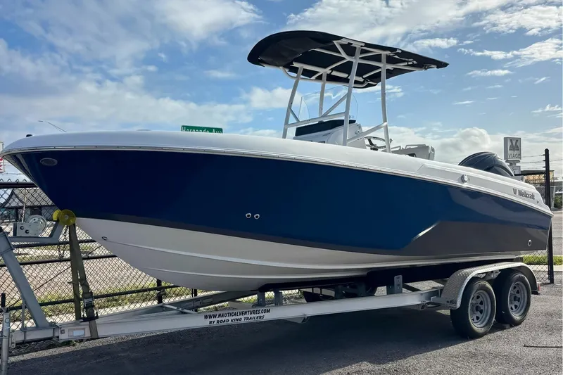 The Image of 2024 Wellcraft 202 Fisherman boat on trailer, blue hull, sunny day. - 0