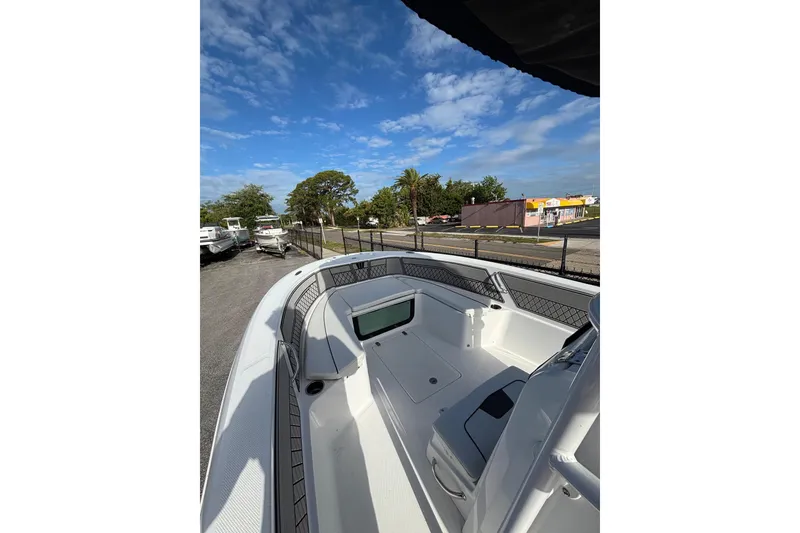 Slide: The Image of 2024 Wellcraft 202 Fisherman boat interior with seating, under a clear blue sky. - 2