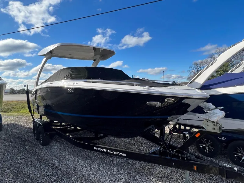Slide: The Image of 2024 Regal LS6 Surf boat on trailer under blue sky. - 1