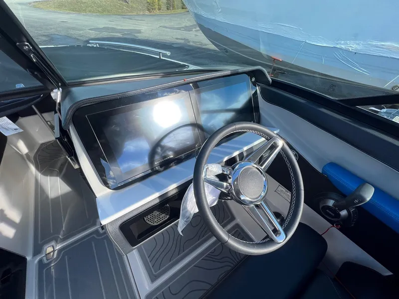 Slide: The Image of 2024 Regal LS6 Surf boat dashboard with modern steering and touchscreen display. - 14