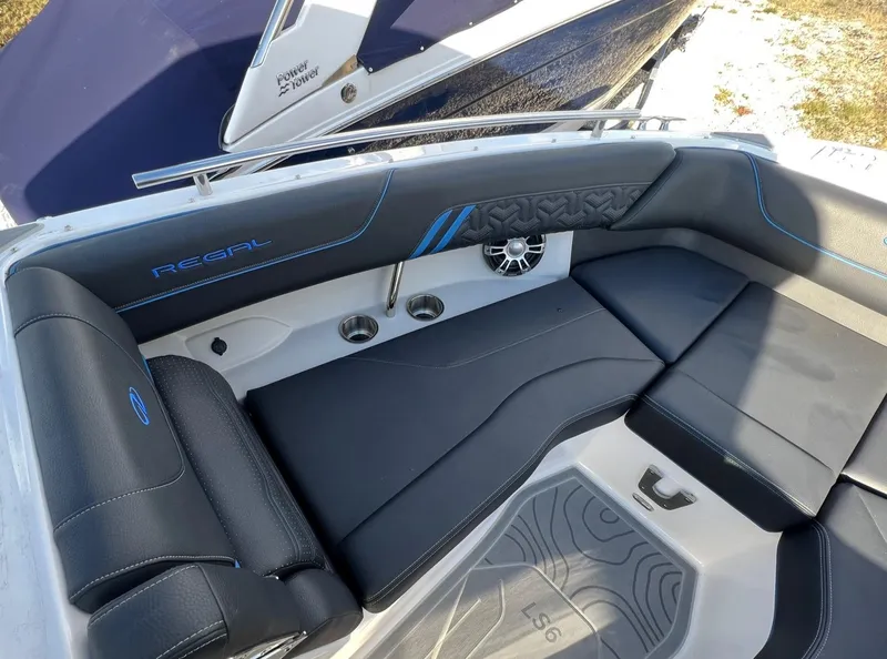 Slide: The Image of 2024 Regal LS6 Surf boat interior with black seating and blue accents. - 20