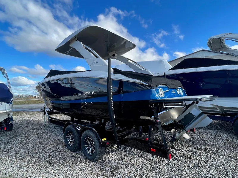 Slide: The Image of 2024 Regal LS6 Surf boat on trailer under blue sky. - 4