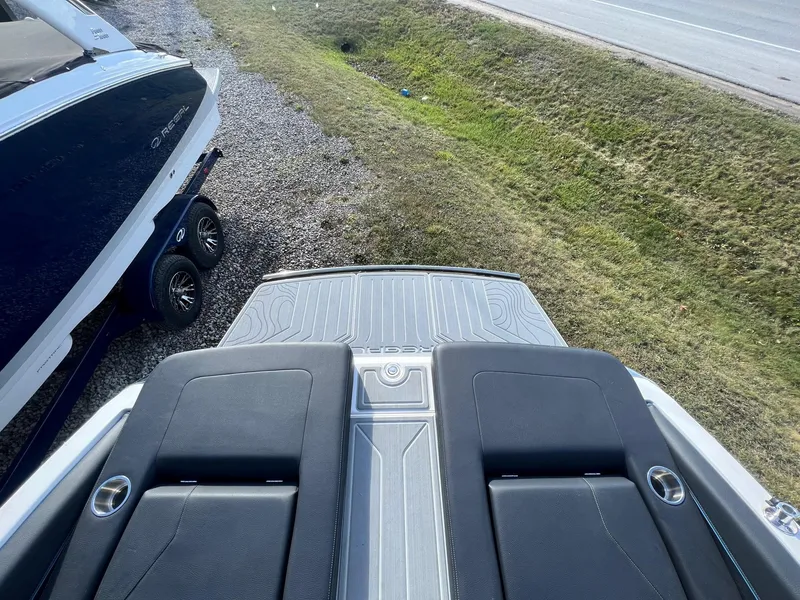 Slide: The Image of 2024 Regal LS6 Surf boat on trailer, rear view, parked on gravel. - 8
