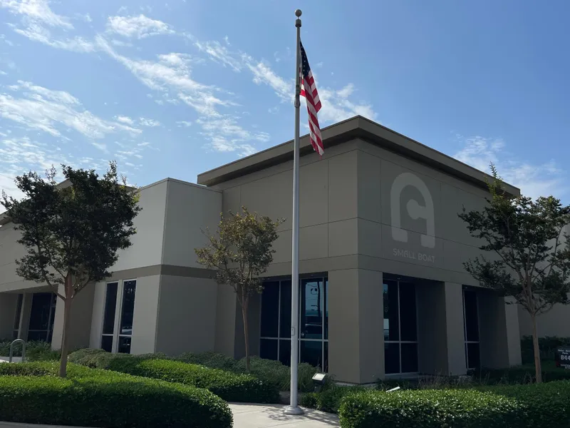 The Image of Modern office building with American flag and landscaped greenery. - 1