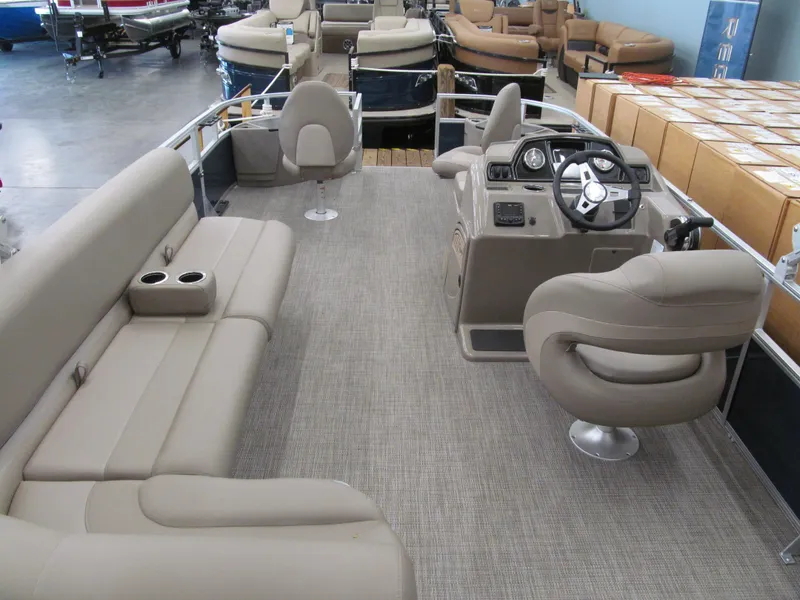 Slide: The Image of 2024 Ranger Reata 200F pontoon boat interior with beige seating and modern helm. - 11