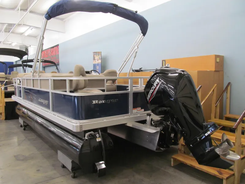 Slide: The Image of 2024 Ranger Reata 200F pontoon boat with Mercury outboard motor in showroom. - 2