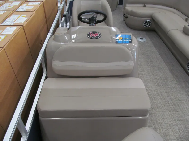 Slide: The Image of 2024 Ranger Reata 200F boat interior with beige seating and steering console. - 5