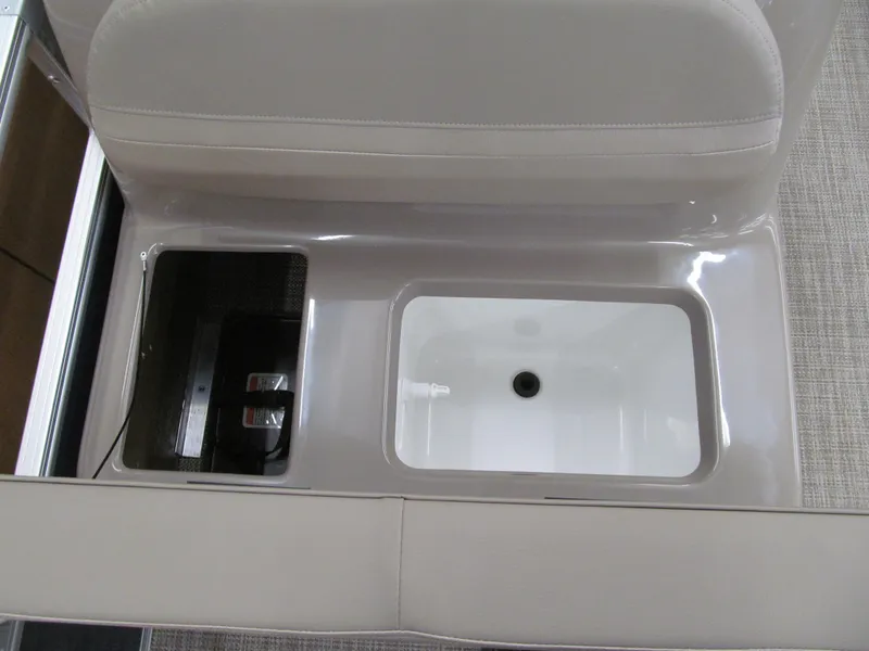 Slide: The Image of 2024 Ranger Reata 200F boat storage compartment with beige seating and integrated cooler. - 6