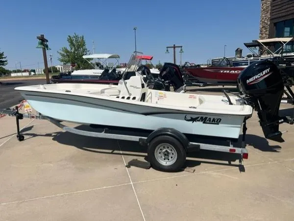 Slide: The Image of 2024 Mako Pro Skiff 15 CC boat on trailer with Mercury outboard motor. - 0