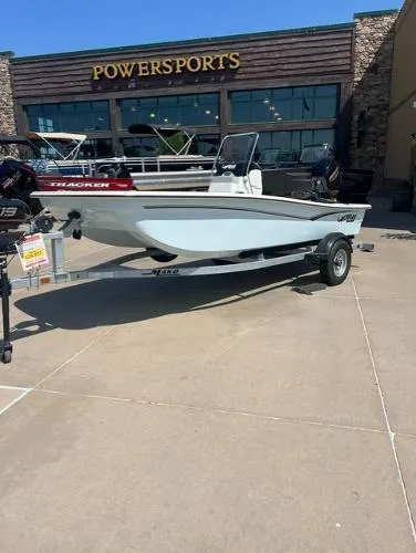 Slide: The Image of 2024 Mako Pro Skiff 15 CC boat displayed outside Powersports dealership. - 1