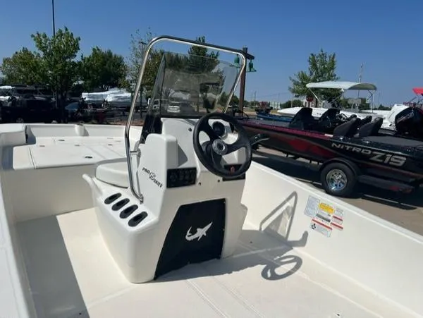 Slide: The Image of 2024 Mako Pro Skiff 15 CC boat interior with steering console and seating. - 2