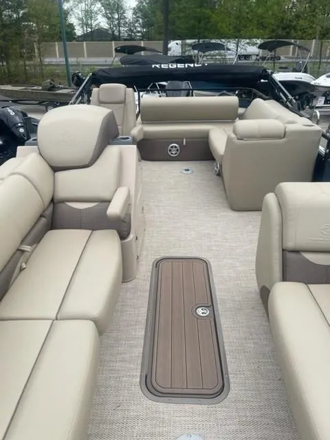 Slide: The Image of 2023 Regency 250 DL3 pontoon boat with luxurious beige seating and spacious deck. - 1