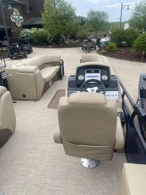 Slide: The Image of 2023 Regency 250 DL3 pontoon boat interior with beige seating and modern dashboard. - 3