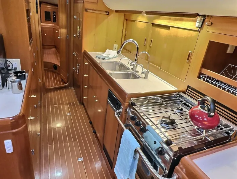 Slide: The Image of Luxurious 2003 Taswell 58 yacht kitchen with wood finish, dual sinks, and stove. - 19