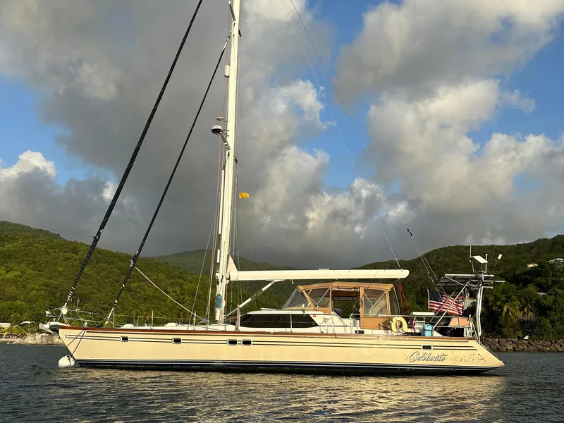 Slide: The Image of Sailing yacht Taswell 58, 2003 model, anchored with scenic mountain backdrop. - 2