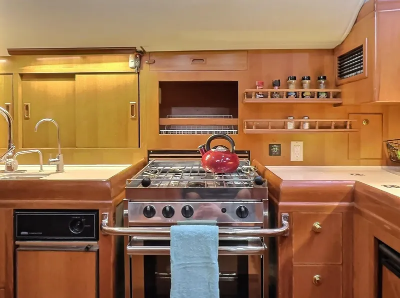 Slide: The Image of Kitchen area of a 2003 Taswell 58 yacht with stove and wooden cabinetry. - 20