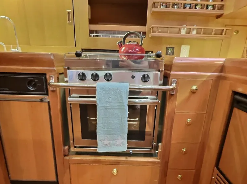 Slide: The Image of Galley kitchen in 2003 Taswell 58 yacht with stove, red kettle, and towel. - 21