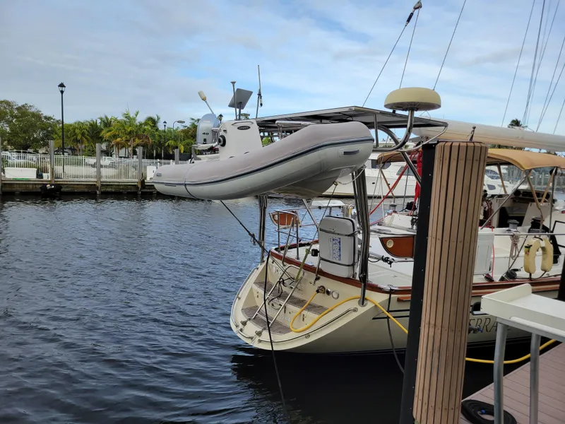 Slide: The Image of Taswell 58 yacht from 2003 docked with dinghy, calm water, and overcast sky. - 4