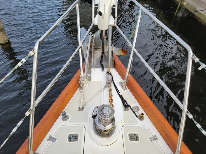 Slide: The Image of Bow of 2003 Taswell 58 yacht with anchor chain and winch, docked on calm water. - 9