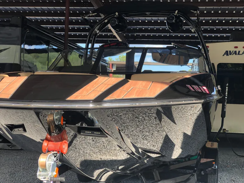 Slide: The Image of 2023 Moomba Makai boat with sleek black design, parked under a shelter. - 10