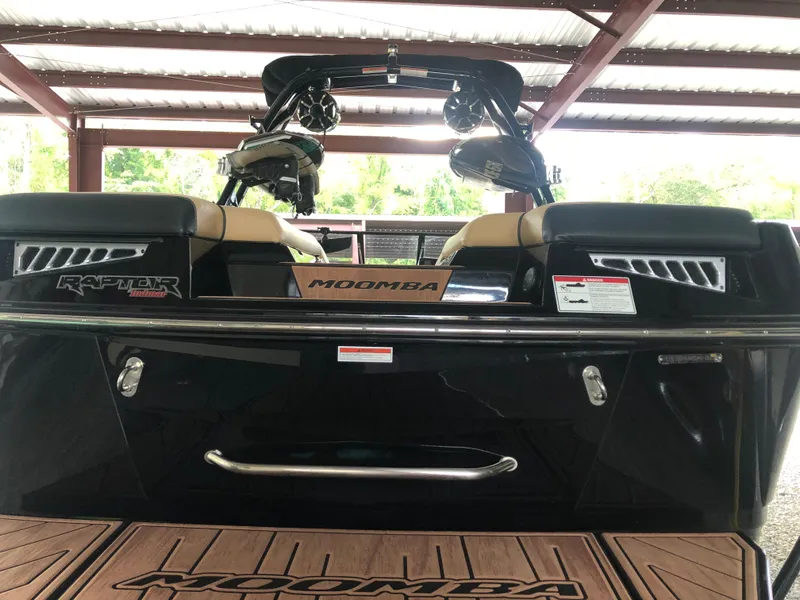 Slide: The Image of 2023 Moomba Makai boat rear view under shelter, featuring Raptor engine. - 14